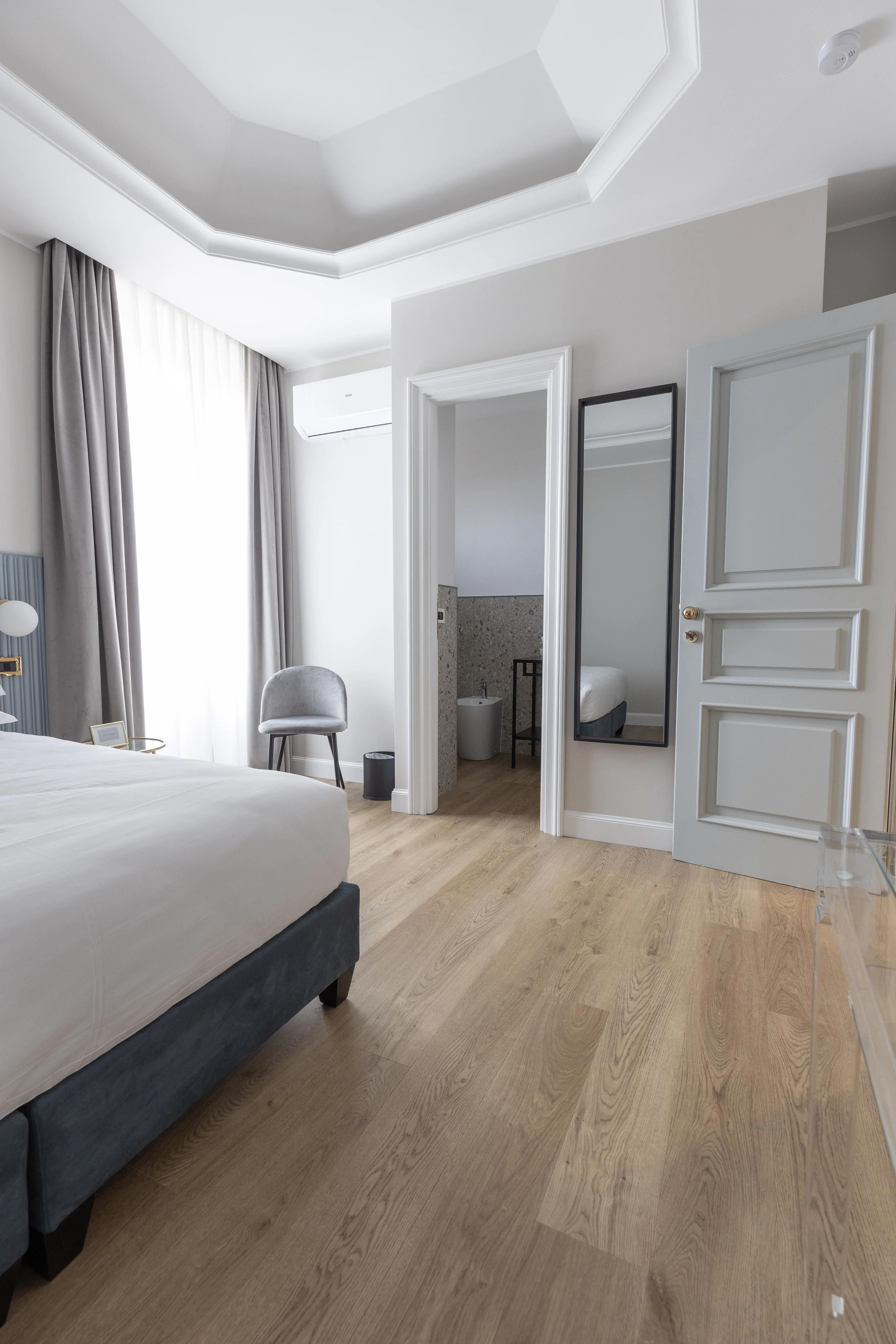 Camera con porta bagno privato e specchio a parete