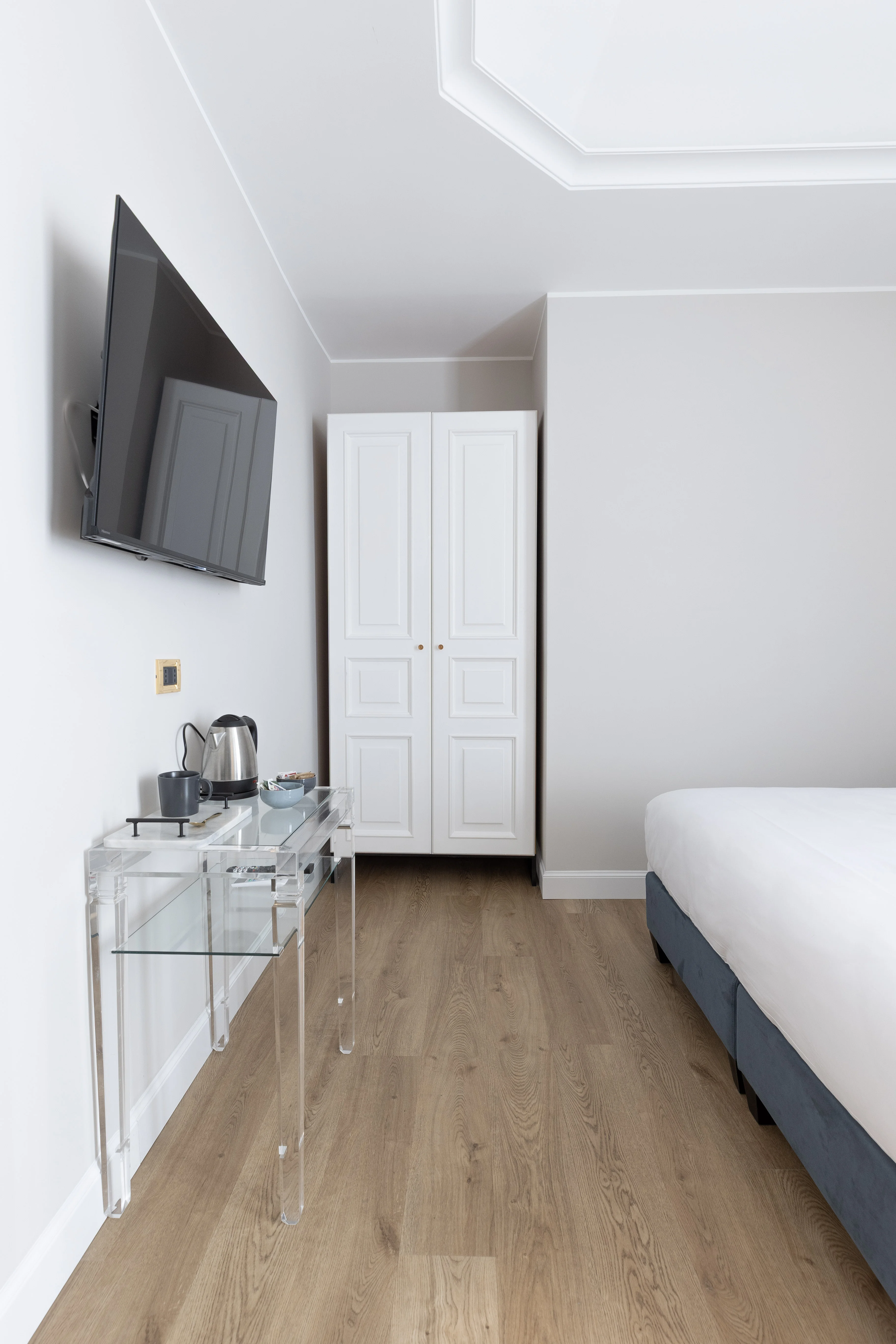 Scrivania trasparente, TV a schermo piatto e armadio