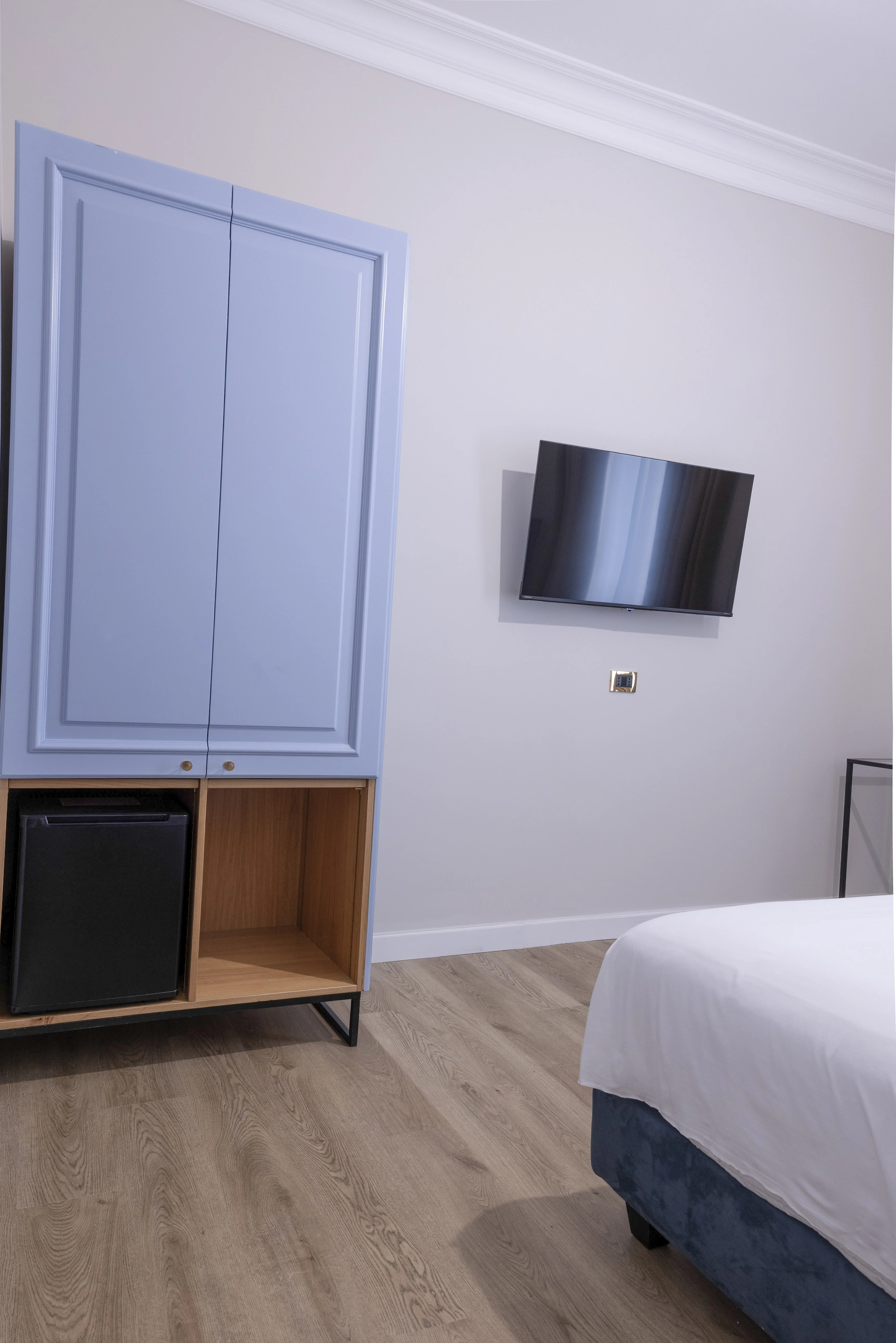 Armadio azzurro con frigobar e TV a schermo piatto