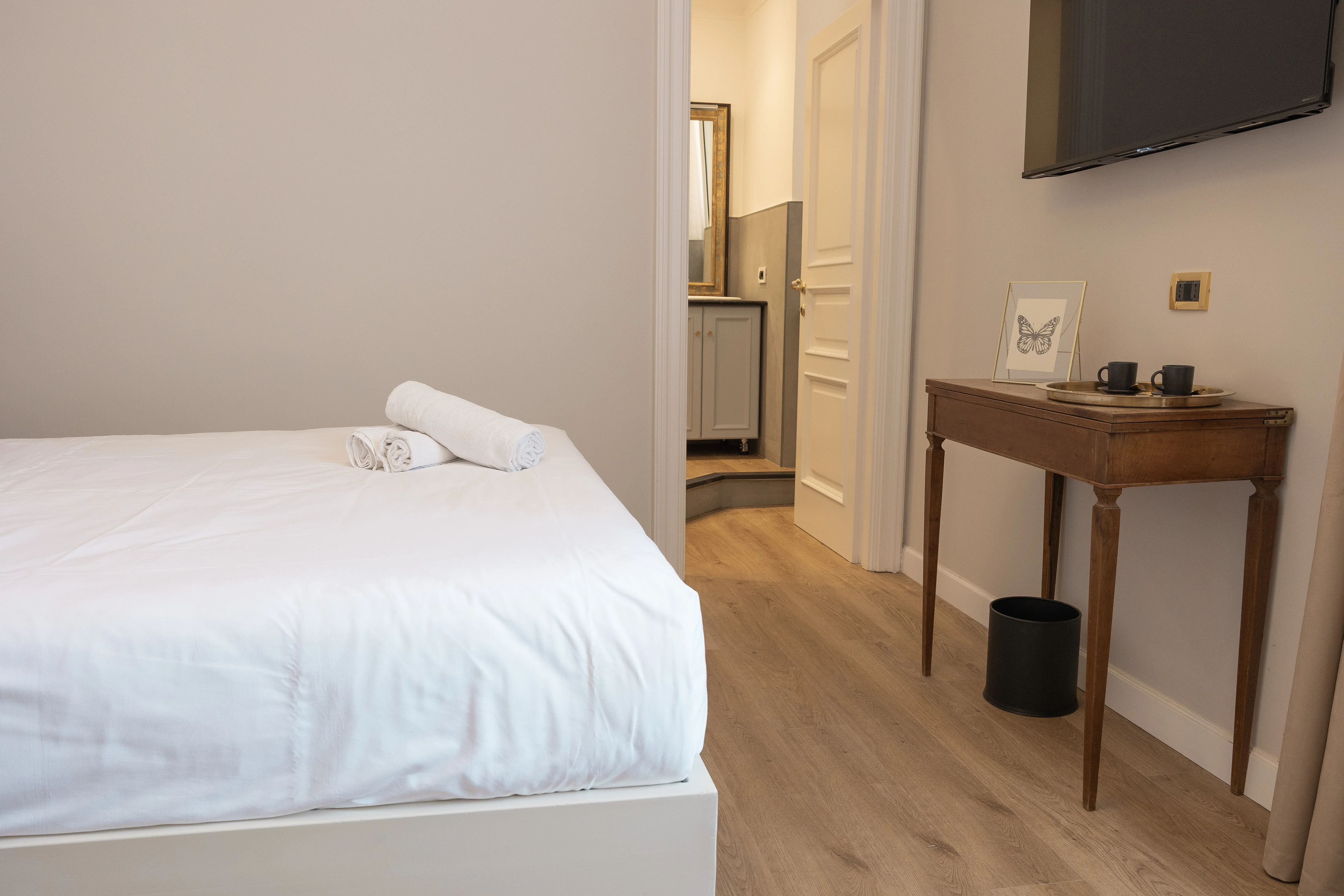 Camera Classic Suite — vista laterale con console in legno antico e TV