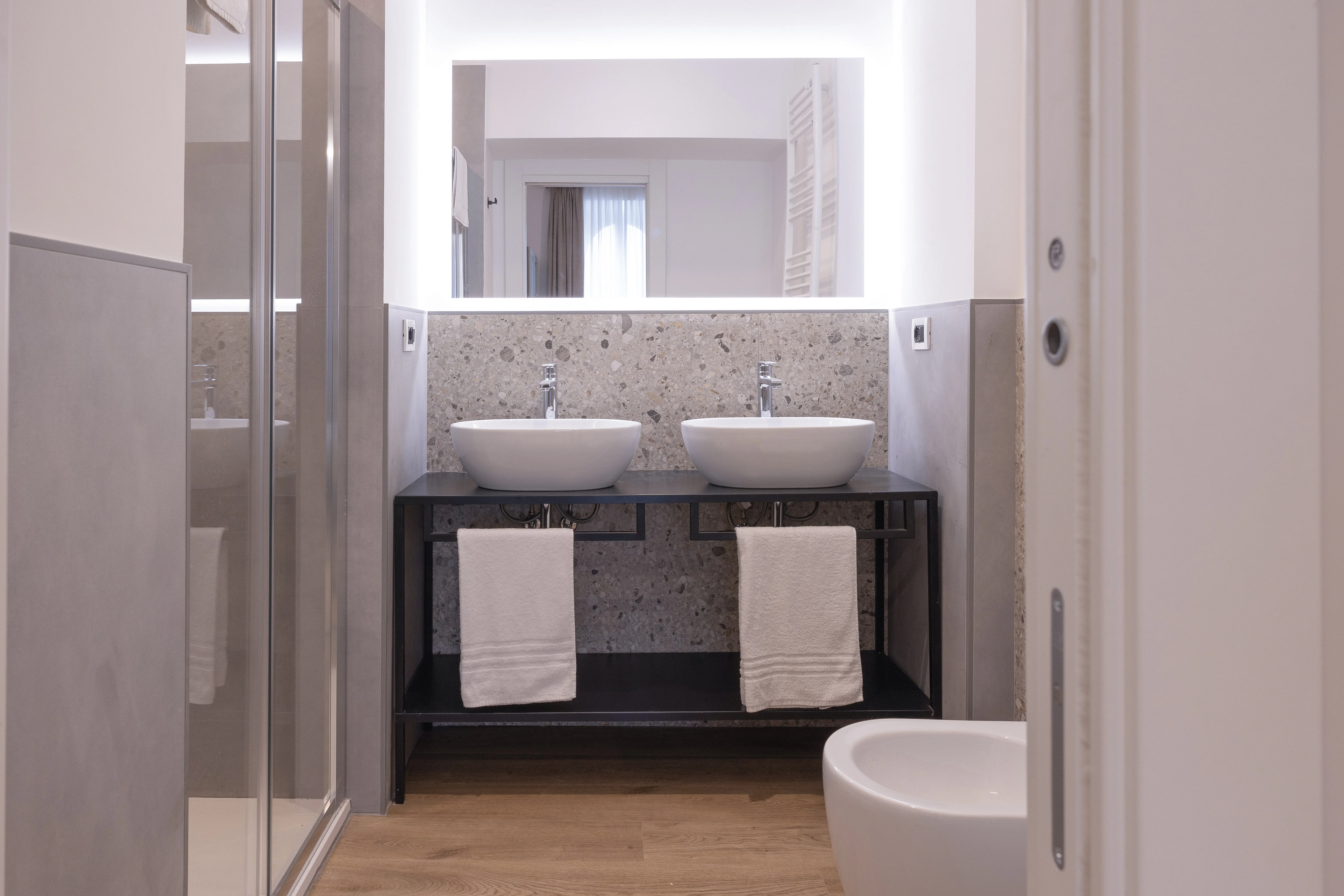 Bagno Camera Deluxe Queen — doppio lavabo con rivestimento in terrazzo e specchio retroilluminato